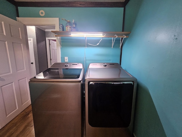 washroom with wood-type flooring, washer and dryer, and ornamental molding