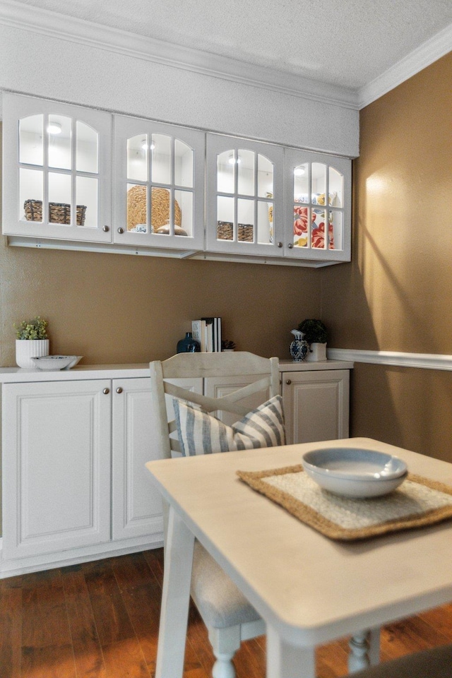 dining room with crown molding and dark wood-type flooring