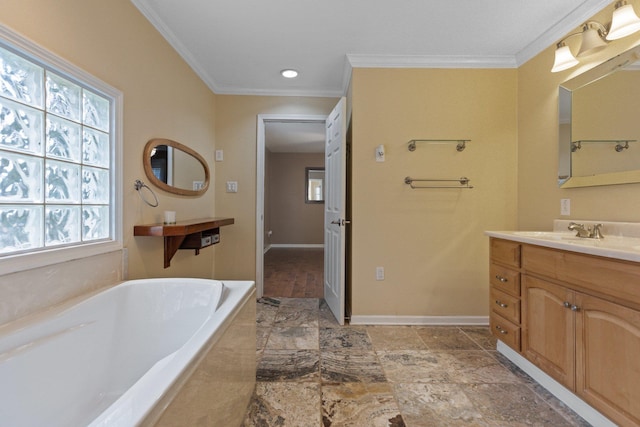 bathroom featuring ornamental molding, plenty of natural light, vanity, and a washtub