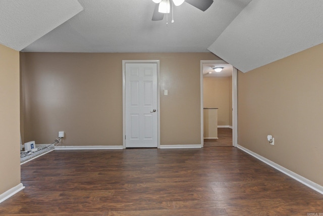 bonus room featuring ceiling fan, dark hardwood / wood-style flooring, vaulted ceiling, and a textured ceiling