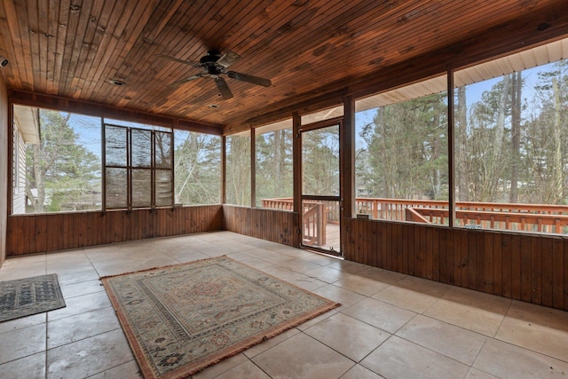 unfurnished sunroom featuring wood ceiling and ceiling fan