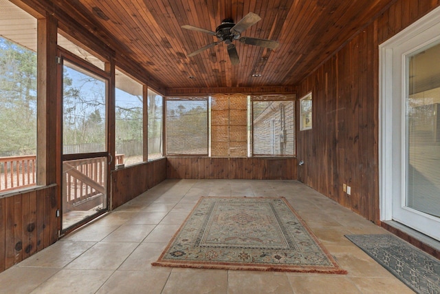 unfurnished sunroom featuring wood ceiling and ceiling fan