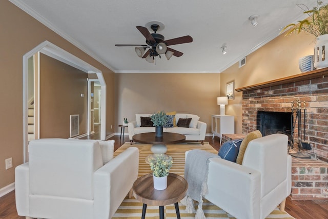 living room with crown molding, a fireplace, and hardwood / wood-style floors