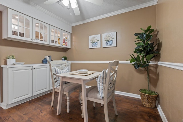 dining space with dark hardwood / wood-style flooring, ceiling fan, ornamental molding, and a textured ceiling