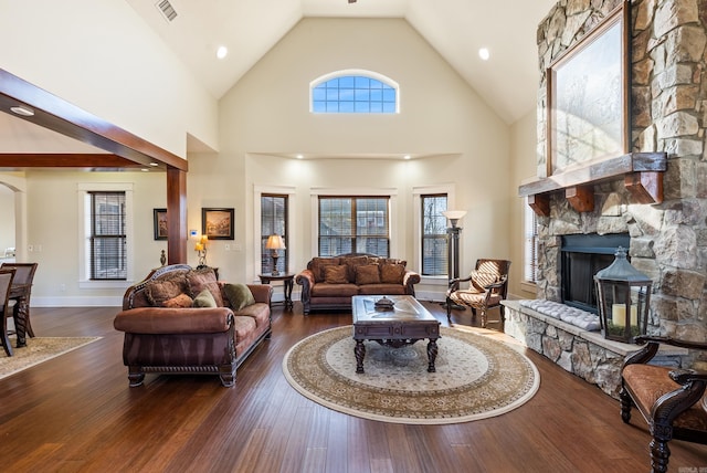 living room featuring a stone fireplace, high vaulted ceiling, and dark hardwood / wood-style floors