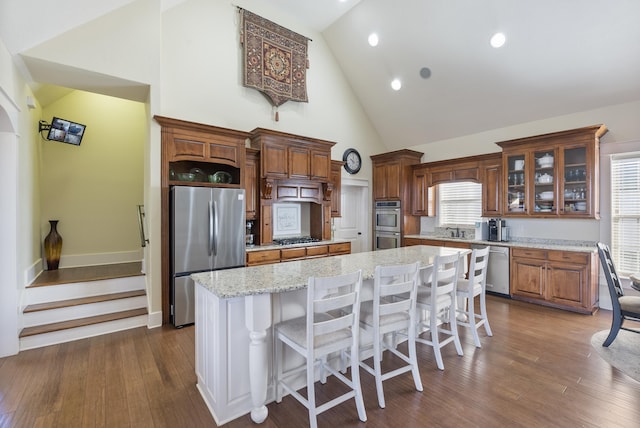 kitchen with high vaulted ceiling, a center island, a healthy amount of sunlight, and appliances with stainless steel finishes