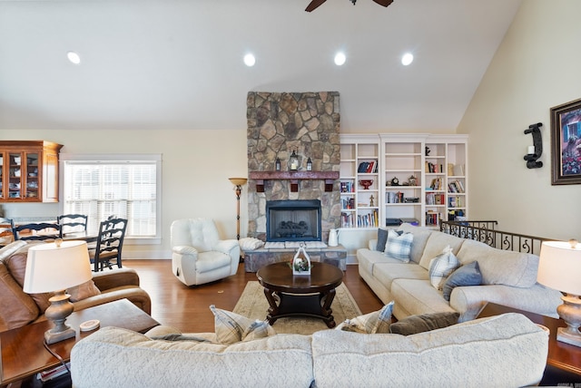 living room with hardwood / wood-style floors, vaulted ceiling, a fireplace, and ceiling fan