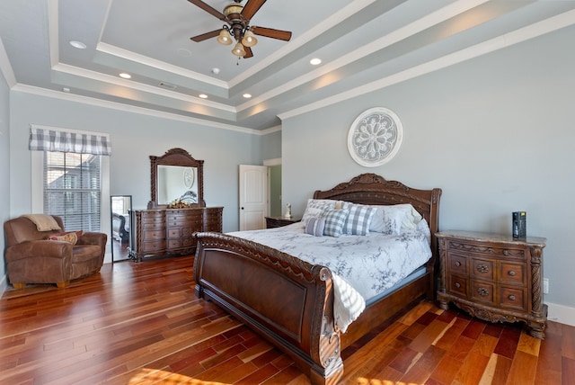 bedroom featuring a raised ceiling, dark hardwood / wood-style flooring, crown molding, and ceiling fan