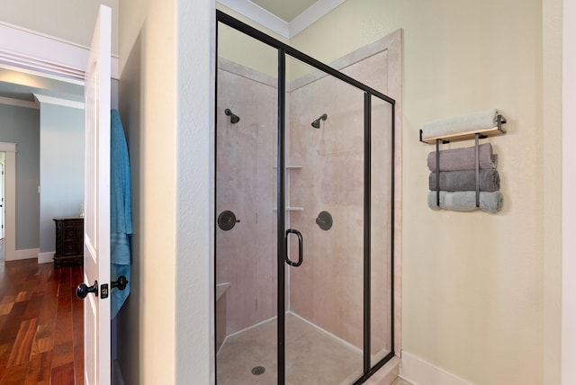 bathroom with a shower with door and hardwood / wood-style floors