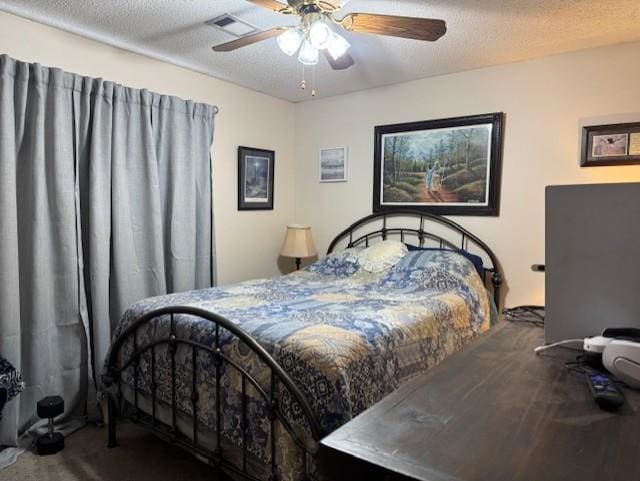 bedroom featuring a textured ceiling, ceiling fan, and carpet flooring