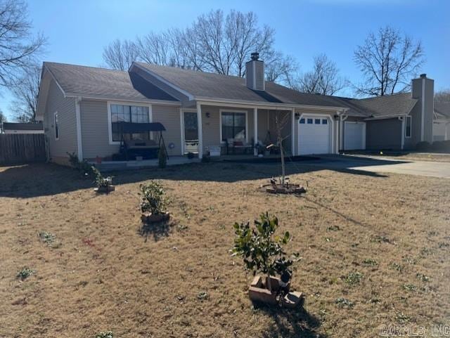 ranch-style home with a garage, a front yard, and covered porch