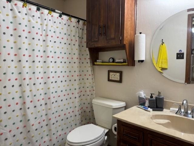 bathroom featuring walk in shower, vanity, and toilet