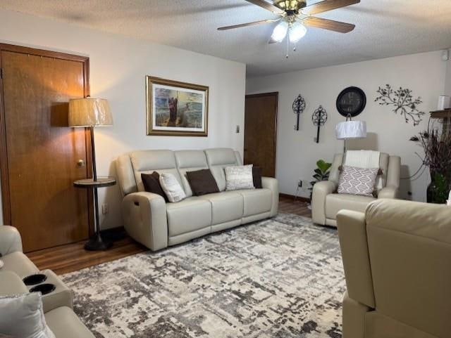 living room featuring ceiling fan, a textured ceiling, and light hardwood / wood-style flooring