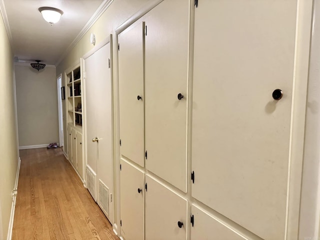 hallway featuring ornamental molding and light wood-type flooring