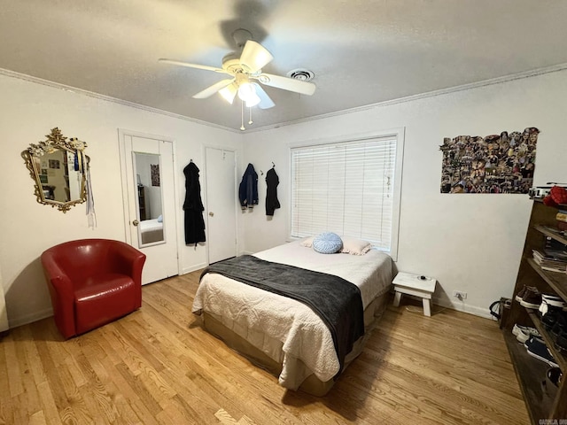 bedroom with crown molding, light hardwood / wood-style flooring, and ceiling fan