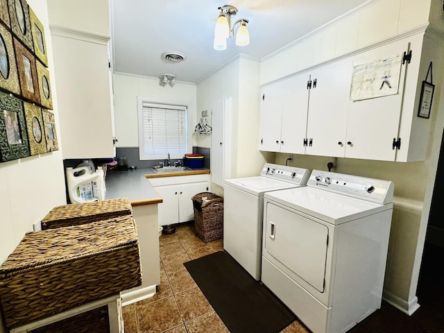 laundry area featuring sink, cabinets, ornamental molding, dark tile patterned floors, and washer and clothes dryer