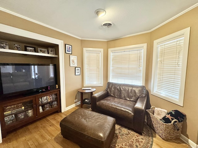 interior space with crown molding, built in shelves, and light hardwood / wood-style flooring