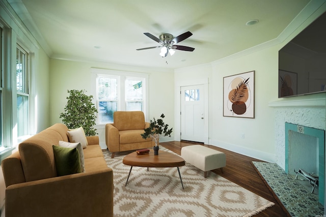 living room featuring ceiling fan, ornamental molding, a premium fireplace, and hardwood / wood-style floors