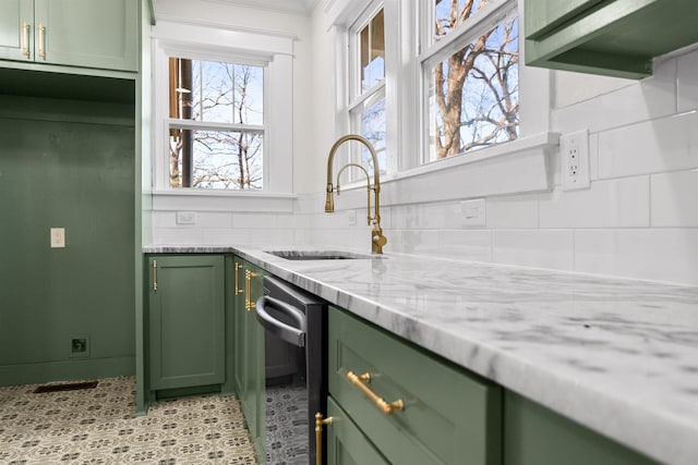 kitchen featuring tasteful backsplash, sink, light stone countertops, and green cabinets