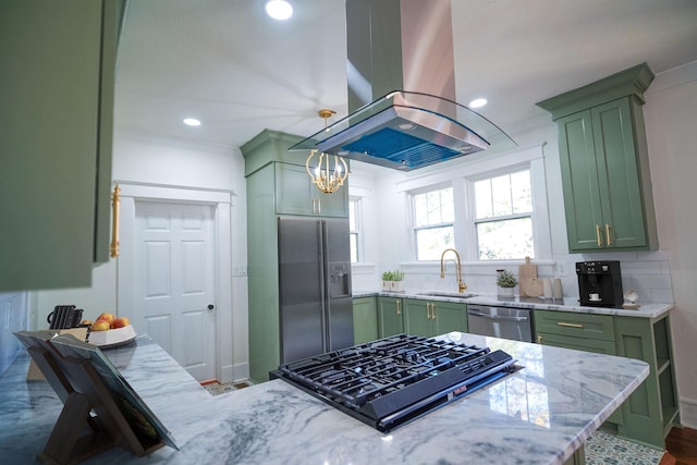 kitchen with appliances with stainless steel finishes, island range hood, sink, green cabinets, and light stone counters