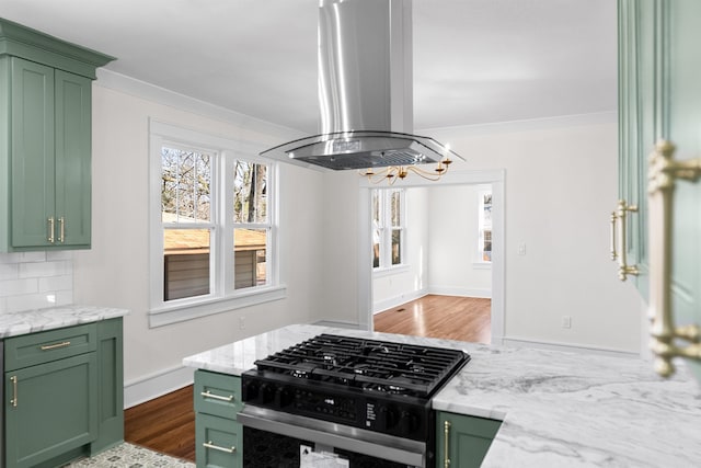 kitchen featuring island range hood, light stone countertops, gas range oven, and green cabinetry