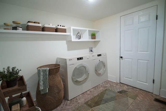 laundry room with independent washer and dryer and dark parquet flooring