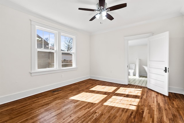 interior space featuring wood-type flooring, ornamental molding, ceiling fan, and ensuite bathroom