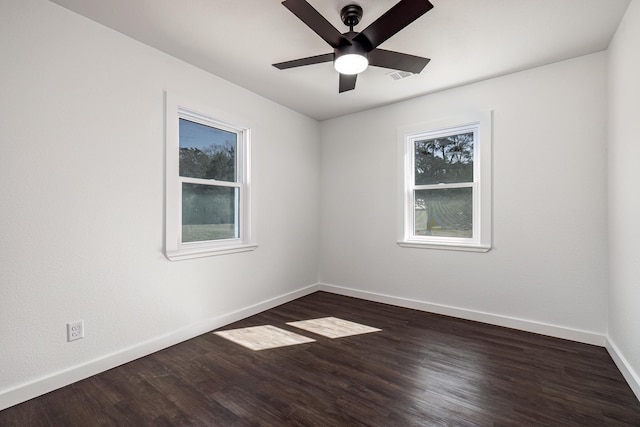 unfurnished room featuring ceiling fan, a wealth of natural light, and dark hardwood / wood-style flooring