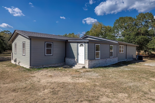 view of front facade with a front yard and central air condition unit