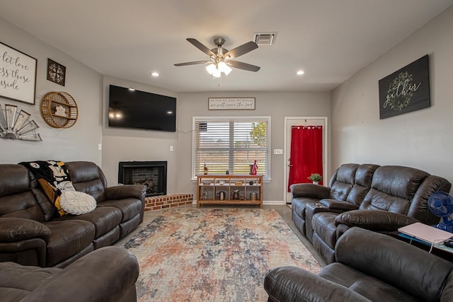 living room featuring ceiling fan and a fireplace