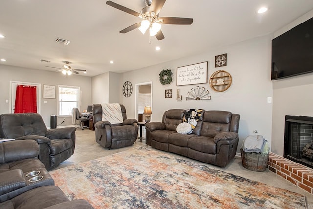 living room with a brick fireplace and ceiling fan