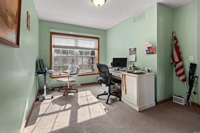 carpeted office featuring a textured ceiling