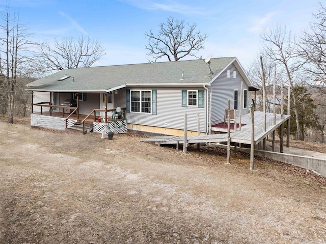 rear view of property featuring a wooden deck