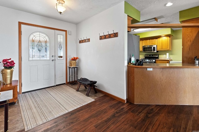 entryway with dark hardwood / wood-style flooring and a textured ceiling