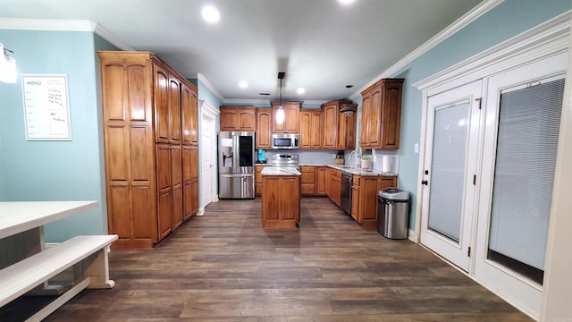 kitchen featuring pendant lighting, sink, crown molding, appliances with stainless steel finishes, and a center island