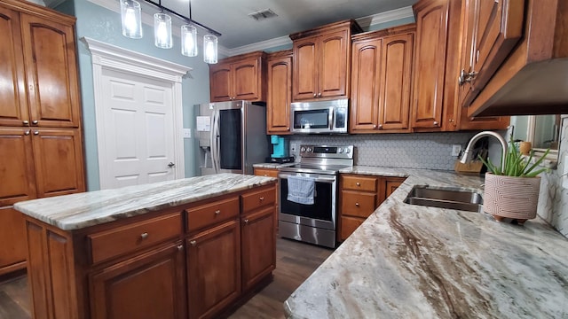 kitchen with tasteful backsplash, light stone counters, stainless steel appliances, and a center island