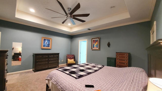 carpeted bedroom featuring a raised ceiling, ornamental molding, and ceiling fan