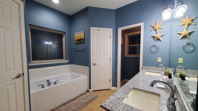 bathroom featuring tile patterned flooring, vanity, and a washtub