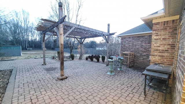 view of patio with area for grilling and a pergola