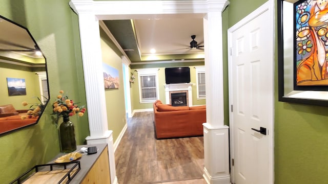 corridor with crown molding, decorative columns, and hardwood / wood-style flooring