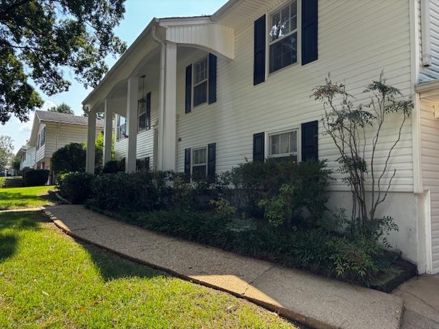 view of side of home with a lawn