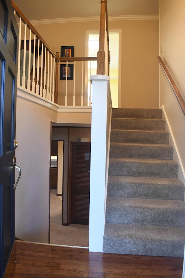 stairway featuring hardwood / wood-style floors and ornamental molding