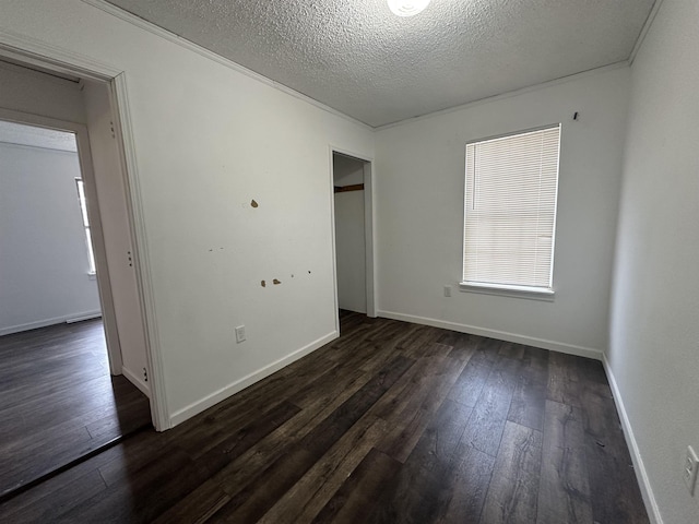 spare room featuring dark hardwood / wood-style floors and a textured ceiling