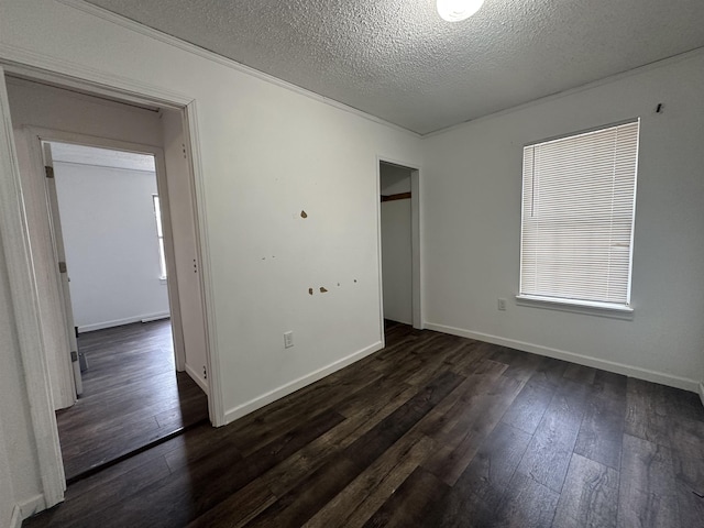 spare room with dark hardwood / wood-style floors and a textured ceiling