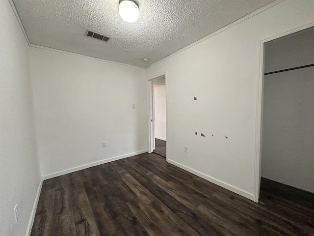 unfurnished bedroom featuring crown molding, dark wood-type flooring, and a textured ceiling