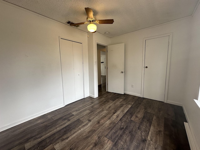 unfurnished bedroom featuring dark hardwood / wood-style floors, a textured ceiling, and ceiling fan