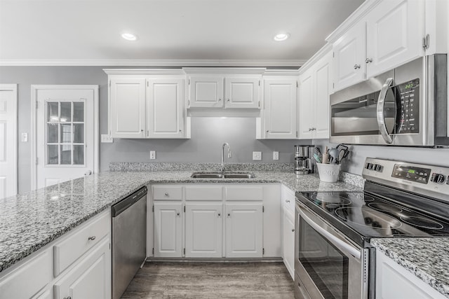 kitchen with sink, light stone counters, ornamental molding, stainless steel appliances, and white cabinets