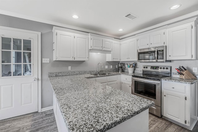 kitchen with white cabinetry, appliances with stainless steel finishes, sink, and wood-type flooring