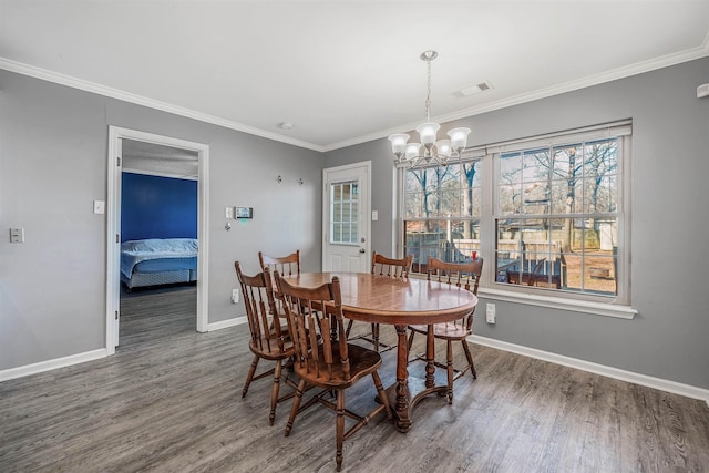 dining area featuring ornamental molding, dark wood-type flooring, and an inviting chandelier