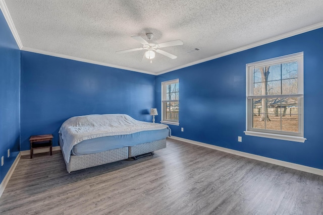 bedroom featuring a textured ceiling, wood-type flooring, ornamental molding, and ceiling fan